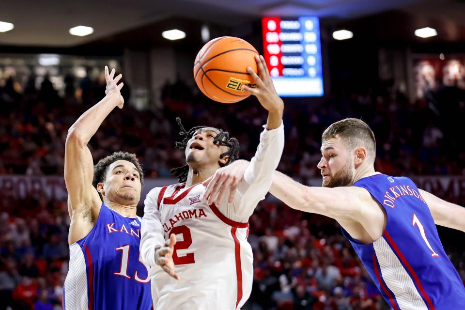 Kansas basketball players Kevin McCullar Jr., Hunter Dickinson attempt to defend Oklahoma guard Javian McCollum during a game Saturday at the Lloyd Noble Center in Norman, Oklahoma.