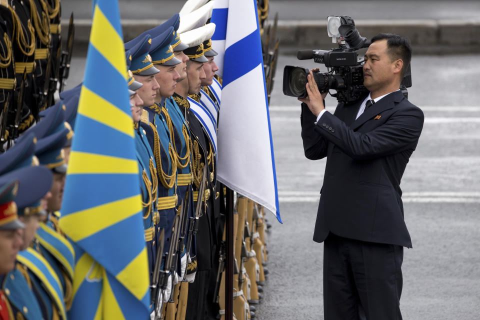 North Korean cameraman takes pictures of honor guards before a wreath-laying ceremony in Vladivostok, Russia, Friday, April 26, 2019. North Korean leader Kim Jong Un paid his respects at a ceremony honoring the war dead Friday to wrap up a brief and generally successful visit to the Russian Far East for his first summit with President Vladimir Putin. (AP Photo/Alexander Khitrov)