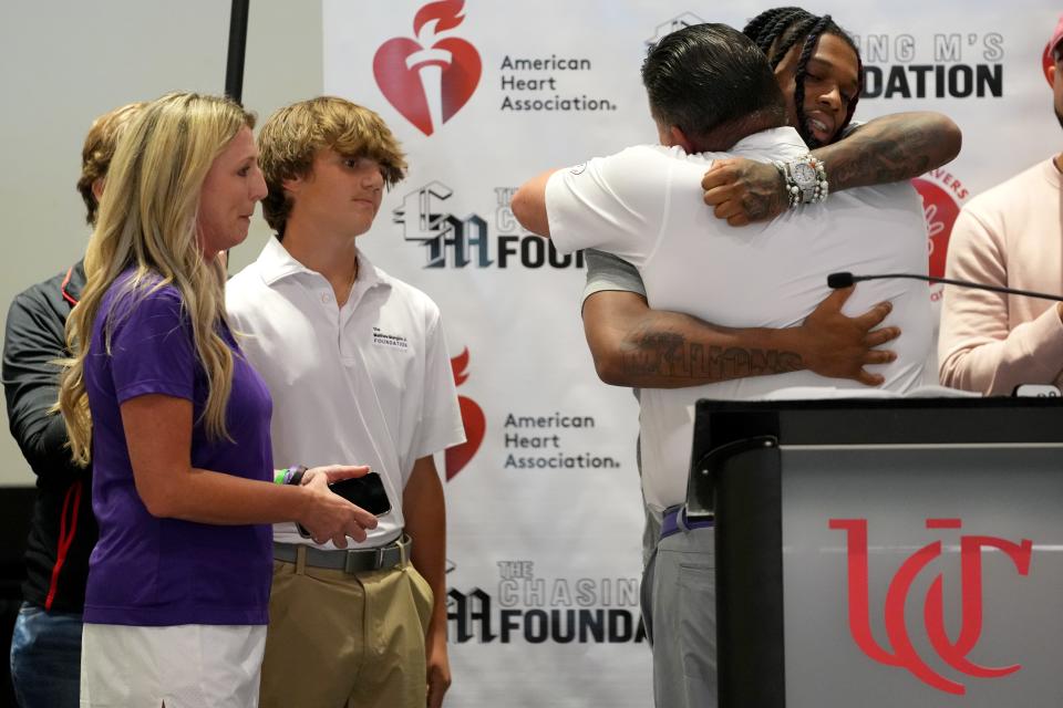 Matt Mangine of Union embraces Buffalo Bills safety Damar Hamlin after delivering remarks during a hands-only CPR event hosted by Hamlin's Chasing M foundation on July 22 at the University of Cincinnati. Mangine was joined by his wife, Kim, and son, Joseph.