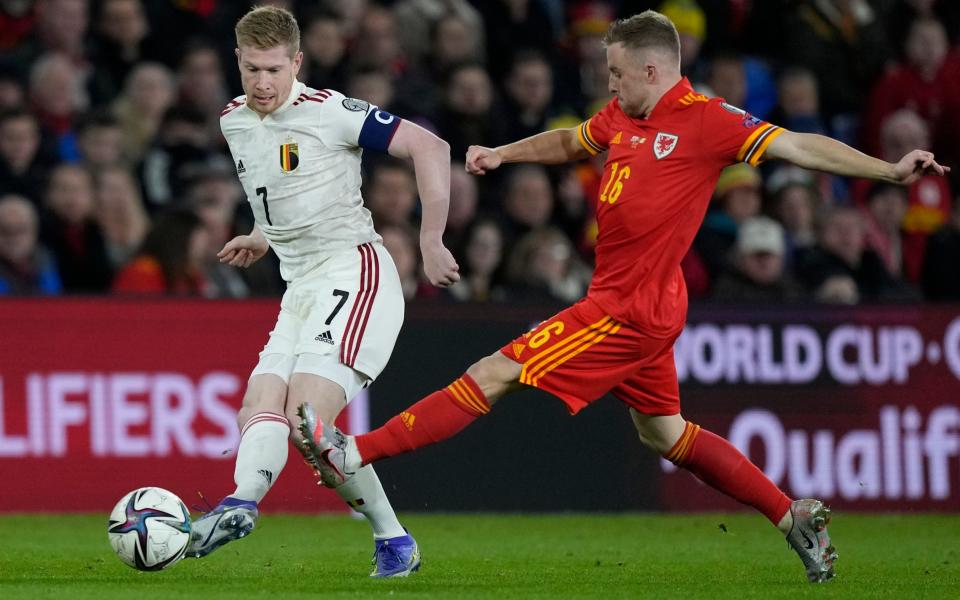 Kevin De Bruyne evades a challenge from Joe Morrell during a qualifying group game between the two nations ahead of this year's World Cup - Kevin De Bruyne admits he is bored of playing Wales - AP