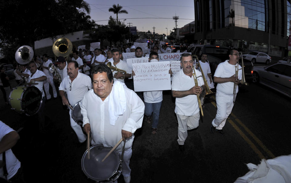 People play music and march in support of jailed drug boss Joaquin Guzman Loera, "El Chapo" in the city of Culiacan, Mexico, Wednesday, Feb. 26, 2014. Hundreds of people marched on the streets of Culiacan, the drug lord's bastion, demanding to free Guzman before they briefly clashed with police who fired tear gas at them. (AP Photo/El Debate de Culiacan-Esthela Chiquete)