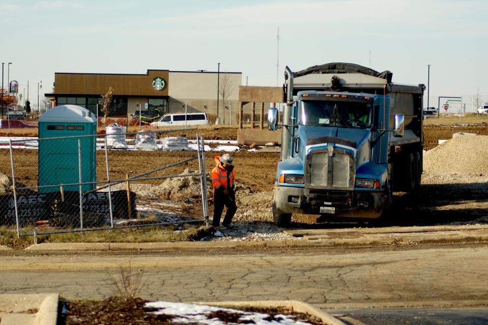 A construction crew works Thursday, Nov. 30, 2023, at the corner East Riverside Boulevard and Galleria Drive in Loves Park, the future home of Buona Beef and The Original Rainbow Cone restaurants.