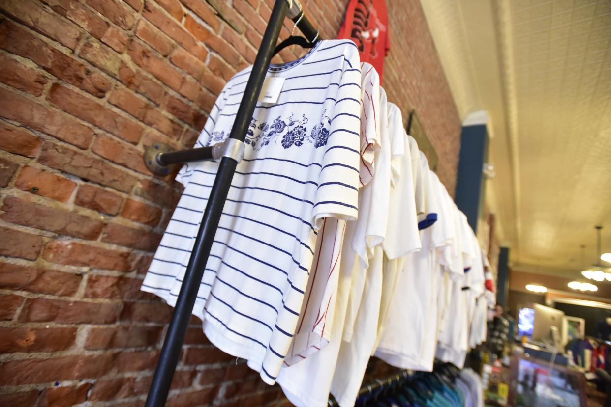 T-shirts hang from clothing racks at Main Street Ensemble in downtown Port Huron on Wednesday, Nov. 16, 2022. Small Business Saturday is an annual event that encourages the community to shop locally for the holidays. All businesses downtown are expected to participate this year.