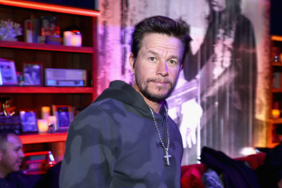 Mark Wahlberg smiles and wears a cross necklace