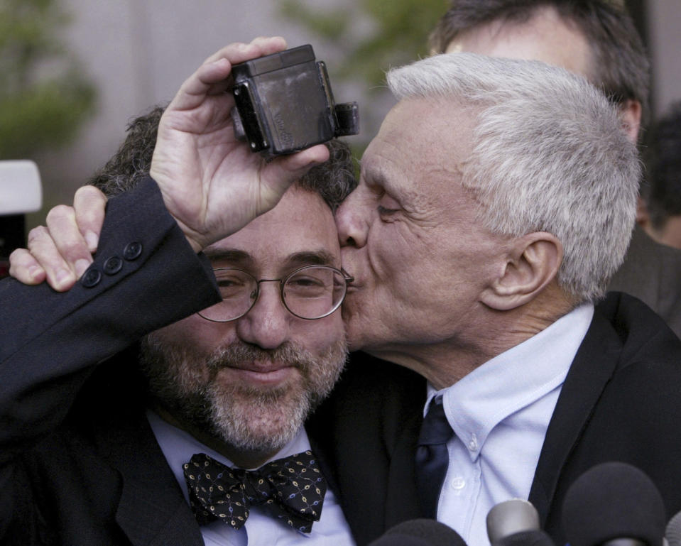 FILE - Robert Blake, right, kisses his attorney M. Gerald Schwartzbach as Schwartzbach holds up Blake's ankle monitor after Blake was found not guilty in his murder trial for the death of his wife Bonny Lee Bakley in Los Angeles, March 16, 2005. Blake, the Emmy award-winning performer who went from acclaim for his acting to notoriety when he was tried and acquitted of murdering his wife, died Thursday, March 9, 2023, at age 89 (AP Photo/Nick Ut, File)