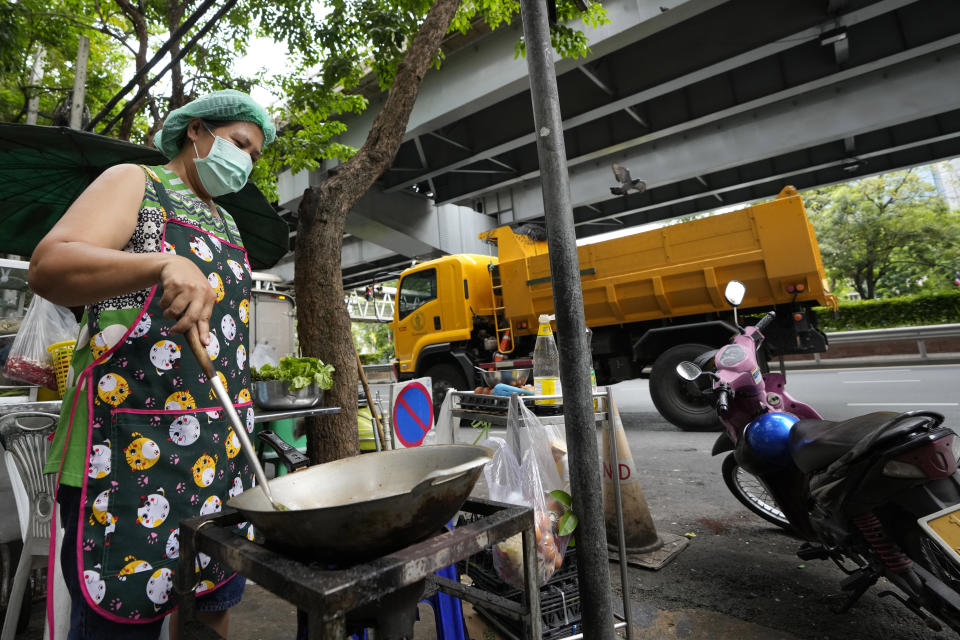 Street food vendor Warunee Deejai cooks lunch for customers in Bangkok, Thailand, Thursday, Aug. 11, 2022. In the six months since Russia invaded Ukraine, the fallout from the war has had huge effects on the global economy. Though intertwined with other forces, the war has made problems like inflation much worse for people around the world. In Bangkok, rising costs for pork, vegetables and oil have forced Warunee Deejai, a street-food vendor, to raise prices, cut staff and work longer hours. (AP Photo/Sakchai Lalit)