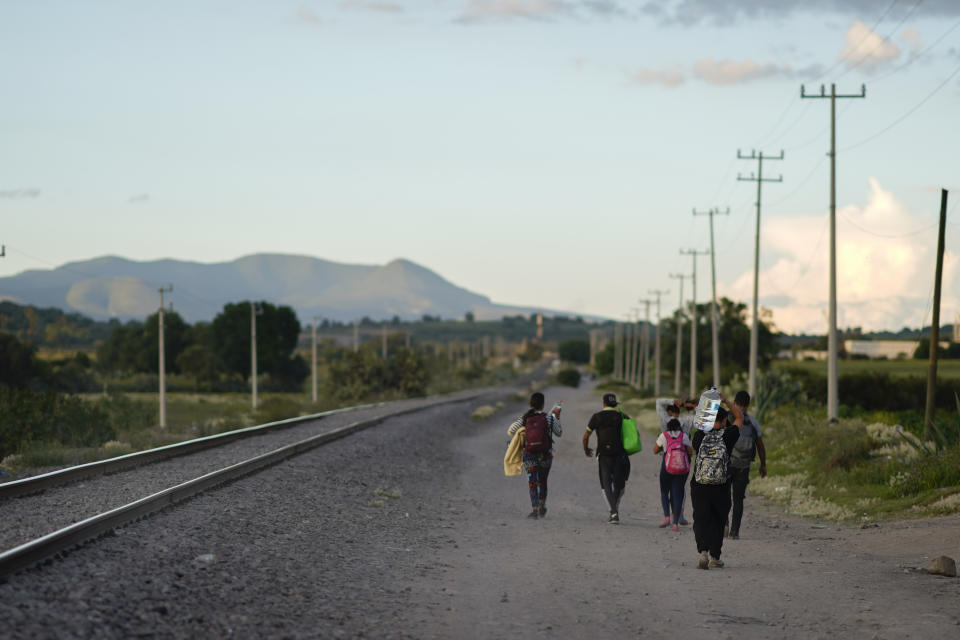 Migrants walks along a rail line hoping to board a freight train heading north, in Huehuetoca, Mexico, Sept. 19, 2023. Ferromex, Mexico's largest railroad company announced that it was suspending operations of its cargo trains due to the massive number of migrants that are illegally hitching a ride on its trains moving north towards the U.S. border. (AP Photo/Eduardo Verdugo)