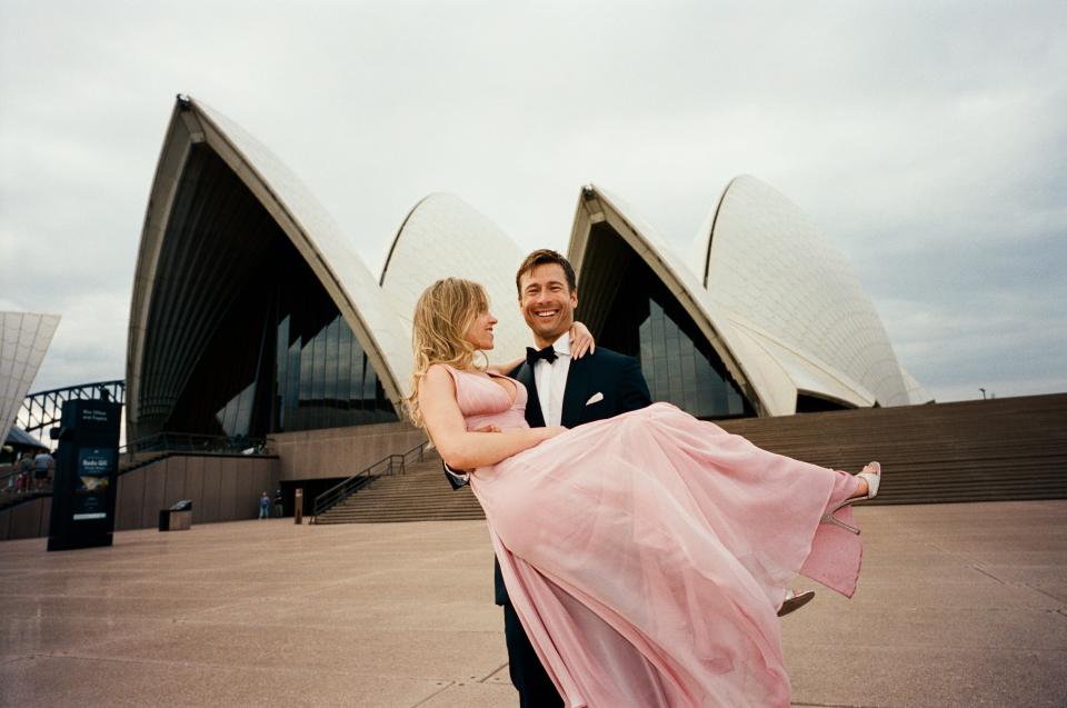 Sydney Sweeney, left, and Glen Powell pose in front of the Sydney Opera House on the set of "Anyone But You" in Australia.