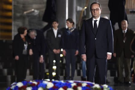 French President Francois Hollande pays his respects after he placed a wreath at the Shoah memorial in Paris, January 27, 2015. President Hollande will attend the International commemorations for the 70th anniversary of the liberation of the Auschwitz death camp later on Tuesday. REUTERS/Martin Bureau/Pool