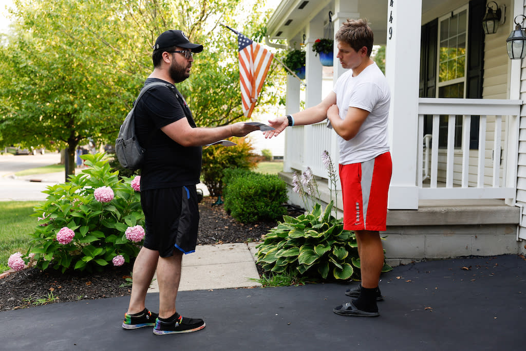 Canvasser hands a man a flyer with information on Ohio's Issue 1.