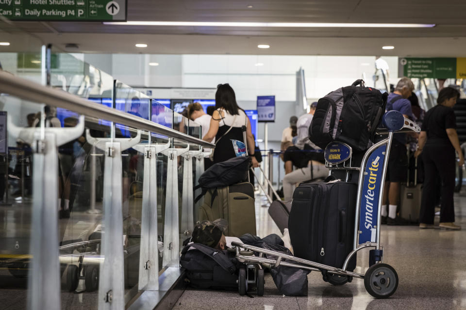 A delayed traveler sleeps on the floor near the United Airlines ticket desk at Terminal C in Newark International Airport in Newark, N.J., Wednesday, June 28, 2023. Airline passengers face delays following flight cancellations due to storms in the region. (AP Photo/Stefan Jeremiah)