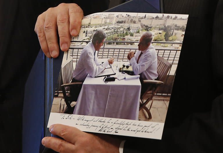 Israeli Prime Minister Benjamin Netanyahu shows a picture that was given to him as a gift by US Secretary of State John Kerry during a meeting in Jerusalem, on May 23, 2013. Kerry flew in to Jerusalem as he kept up a push to bring Israelis and Palestinians back to peace negotiations amid a growing scepticism over his efforts. AFP PHOTO/POOL/JIM YOUNG