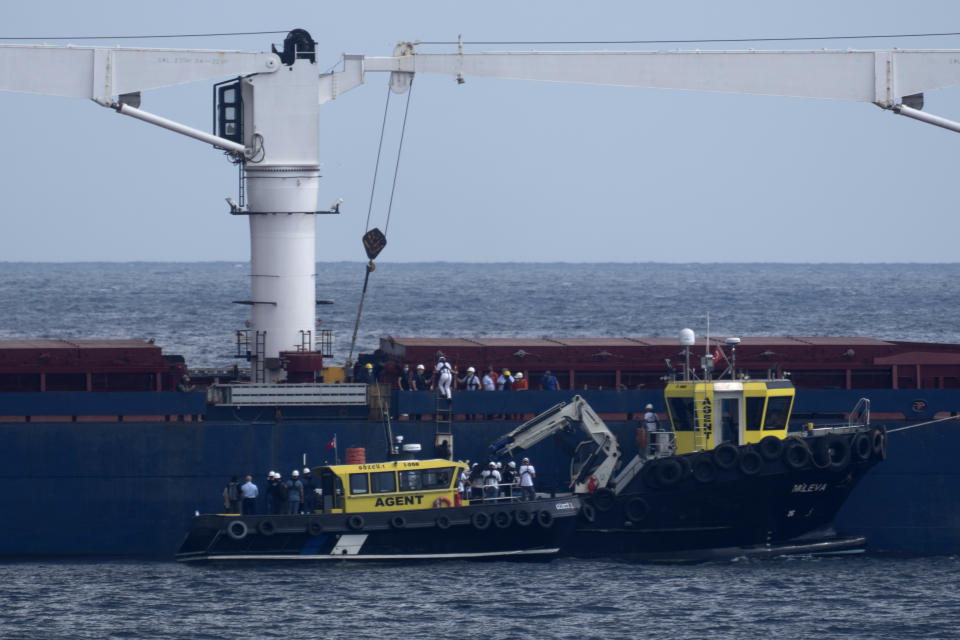 Russian, Ukrainian, Turkish and U.N. officials arrive to the cargo ship Razoni for inspection while it is anchored at the entrance of the Bosphorus Strait in Istanbul, Turkey, Wednesday, Aug. 3, 2022. The Sierra Leone-flagged Razoni, loaded up with 26,000 tons of corn, is the first cargo ship to leave Ukraine since the Russian invasion, and set sail from Odesa Monday, August 1, 2022. Its final destination is Lebanon. (AP Photo/Khalil Hamra)