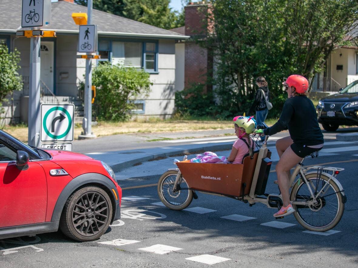 A cyclist in Victoria shown transporting precious cargo. Adding better infrastructure for bicycles makes cities more equitable, according to professor and active transportation researcher Dr. Meghan Winters.  (Mike McArthur/CBC - image credit)