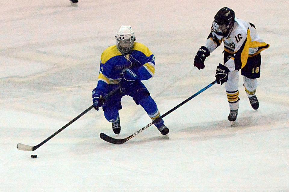 Brady Huff of the Aberdeen Cougars advances the puck against Jacob Rieffenberger of the Watertown Lakers during their SDAHA varsity boys hockey game on Tuesday, Dec. 20, 2022 in Watertown's Maas Ice Arena. Aberdeen pulled away for a 6-3 win.