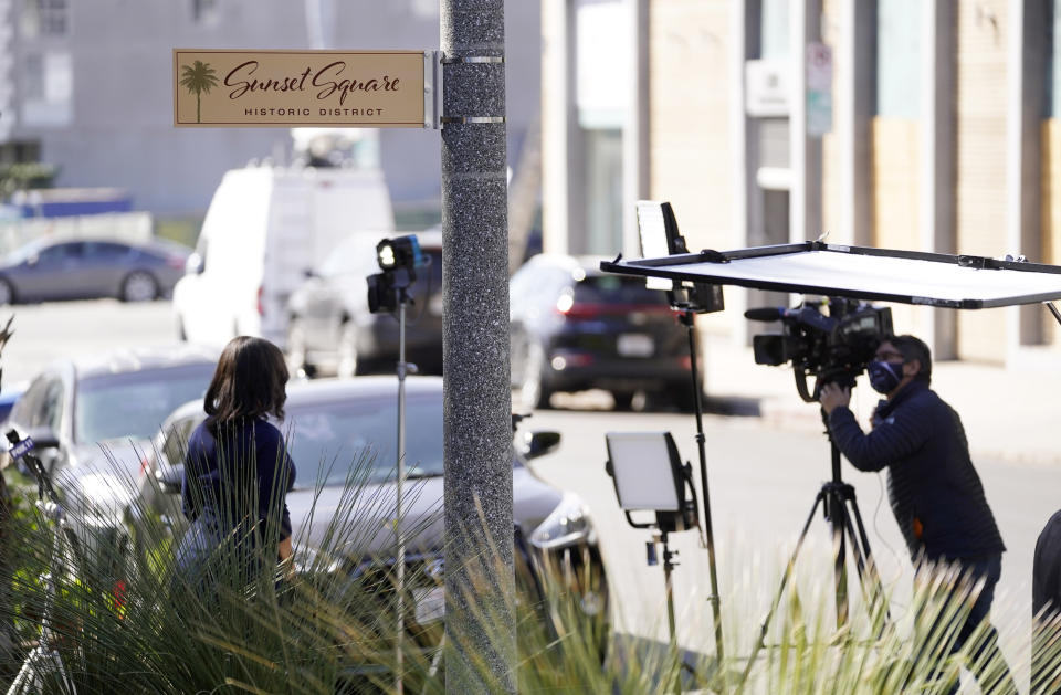 Members of the media congregate near an area on North Sierra Bonita Ave. where Lady Gaga's dog walker was shot and two of her French bulldogs stolen, Thursday, Feb. 25, 2021, in Los Angeles. The dog walker was shot once Wednesday night and is expected to survive his injuries. The man was walking three of Lady Gaga's dogs at the time but one escaped. (AP Photo/Chris Pizzello)