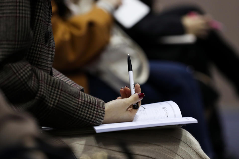 A job seeker holds a pen with an information booklet at a job fair. Photographer: SeongJoon Cho/Bloomberg