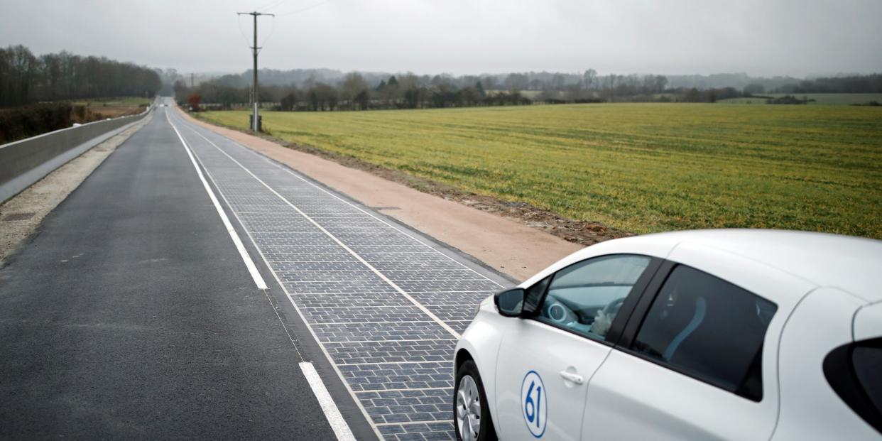 An automobile drives on a solar panel road during its inauguration in Tourouvre