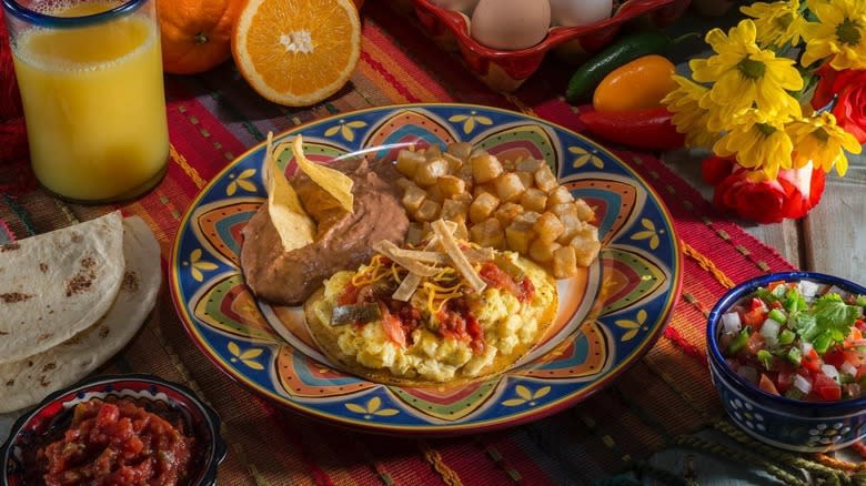 huevos rancheros with potatoes on colorful table