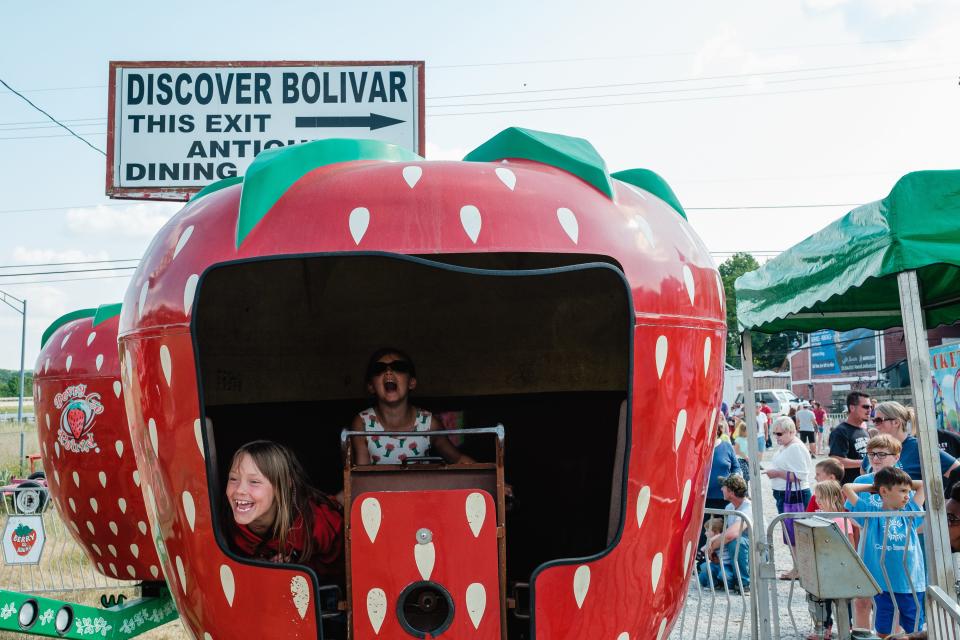 Kendall Dyer, (center) 8, of Bolivar, and her friend, Kaylee Blayloch, 8, also of Bolivar, scream at their parents while riding the 'Berry Go Round' during the Bolivar Strawberry Festival Friday, June 9, in Bolivar.