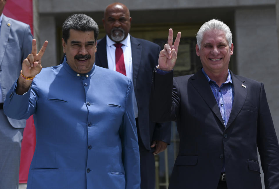 Venezuela's President Nicolas Maduro, left, and Cuba's President Miguel Diaz Canel, flash V-signs as they pose for a group photo during the XXI ALBA Summit at the Palace of the Revolution, in Havana, Cuba, Friday, May 27, 2022. (Yamil Lage/Pool Photo via AP)