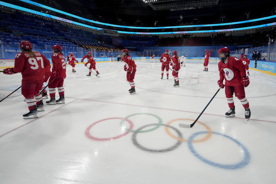 Russian Olympic Committee players warm up before a preliminary round women's hockey game against Canada at the 2022 Winter Olympics, Monday, Feb. 7, 2022, in Beijing. The players left the ice as the game was delayed. Both teams returned wearing COVID masks. (AP Photo/Petr David Josek)
