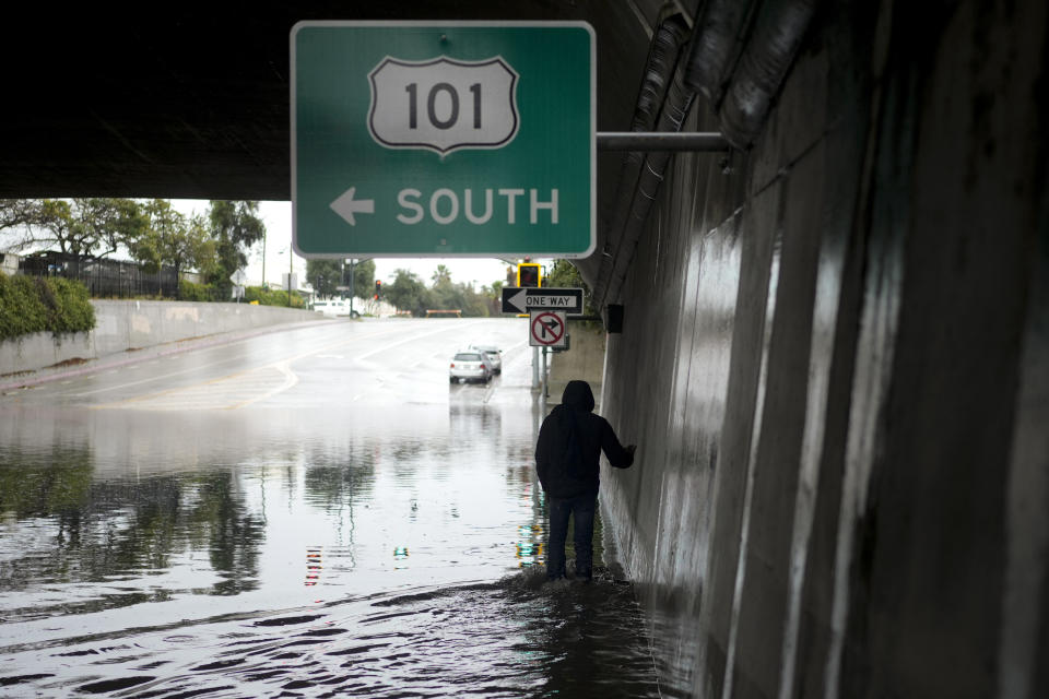 A pedestrian walks under a flooded freeway underpass during a rainstorm, Thursday, Dec. 21, 2023, in Santa Barbara, Calif. (AP Photo/Jae C. Hong)