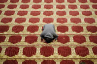 A worshipper prays upon arrival before he and and others gather to perform an Eid al-Fitr prayer at the Masjidullah Mosque in Philadelphia, Thursday, May 13, 2021. (AP Photo/Matt Rourke)