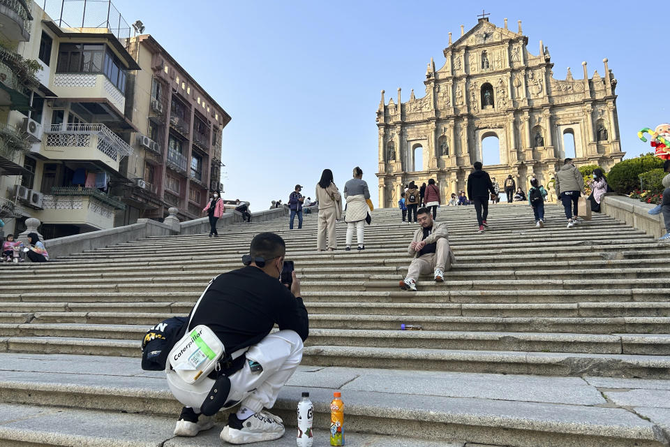 Tourists take photos at the historic site Ruins of St. Paul’s in Macao on Dec. 28, 2022. Gambling haven Macao’s relaxation of border restrictions after China rolled back its "zero-COVID" strategy is widely expected to boost its tourism-driven economy. (AP Photo/Kanis Leung)