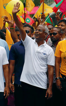 Ibrahim Mohamed Solih, Maldivian presidential candidate backed by the opposition coalition, waves as he stands next to his supporters during the final campaign rally ahead of the presidential election in Male, Maldives September 22, 2018. REUTERS/Ashwa Faheem