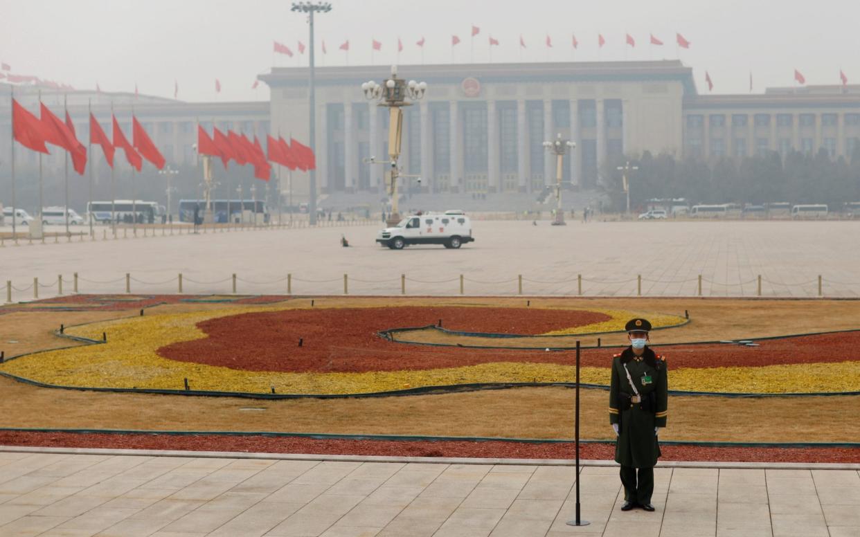 A paramilitary police officer stands guard on Tiananmen Square shrouded in smog - CARLOS GARCIA RAWLINS /REUTERS 