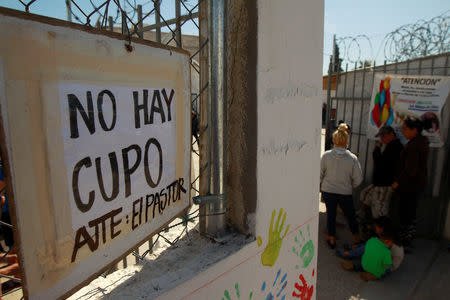 Cuban migrants, waiting for their appointment to request asylum in the U.S., stand near a sign that says the shelter is at full capacity at a church being used as a shelter in Ciudad Juarez, Mexico, February 25, 2019. REUTERS/Jose Luis Gonzalez