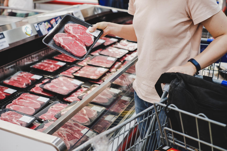 woman shopping at meat section of supermarket