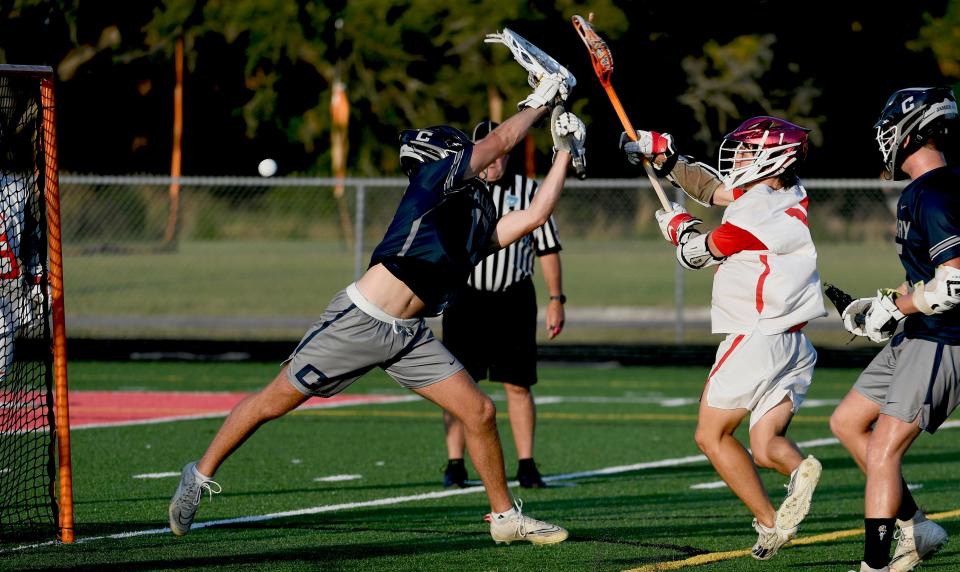 Calvary Christian's lacrosse goalie Tripp Wimberly (#17) couldn't make the block as Cardinal Mooney Catholic's Jamison McCusker (#15) scores in the first quarter of play during the Class 1A Regional semifinal playoff game hosted by Cardinal Mooney Catholic at Austin Smithers Stadium at John Heath Field in Sarasota.