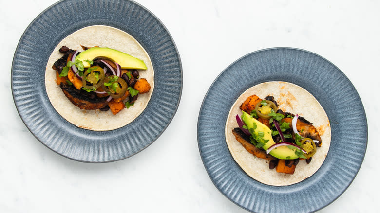 Two open tacos on plates