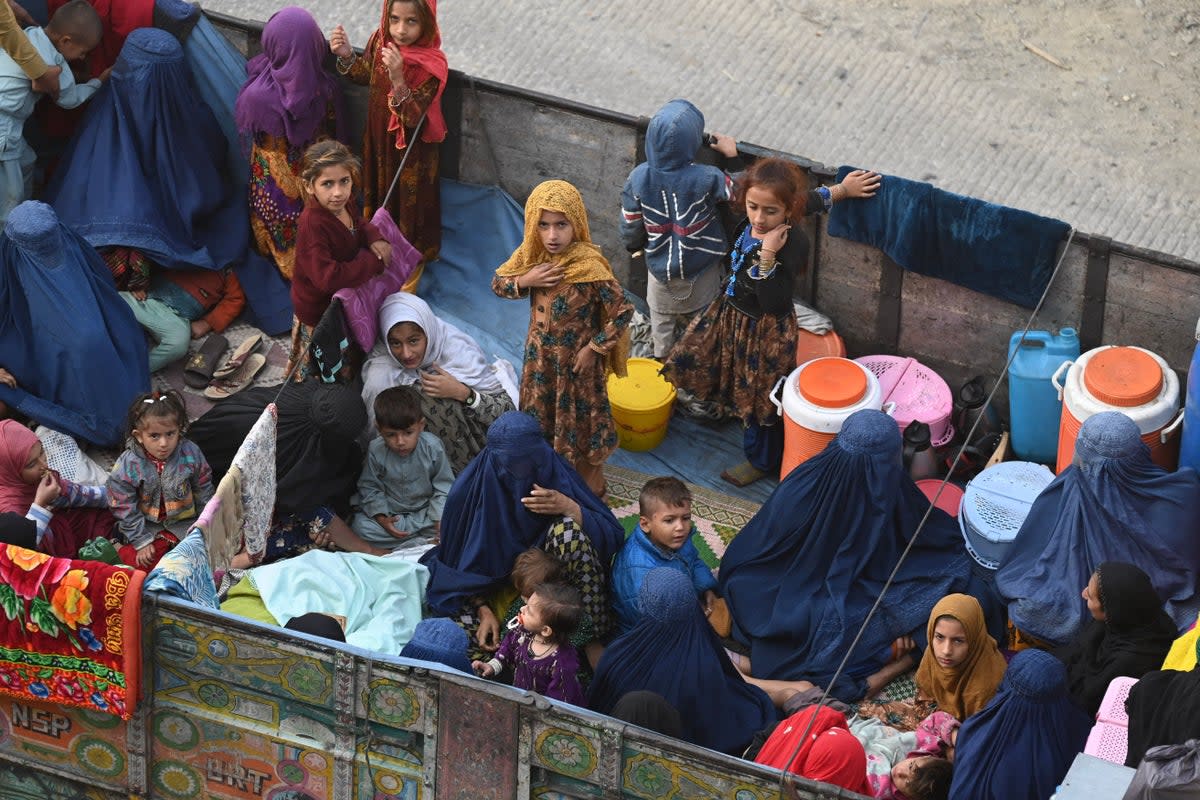 Afghan refugee families sit on a truck heading towards the Pakistan-Afghanistan Torkham border (AFP via Getty Images)