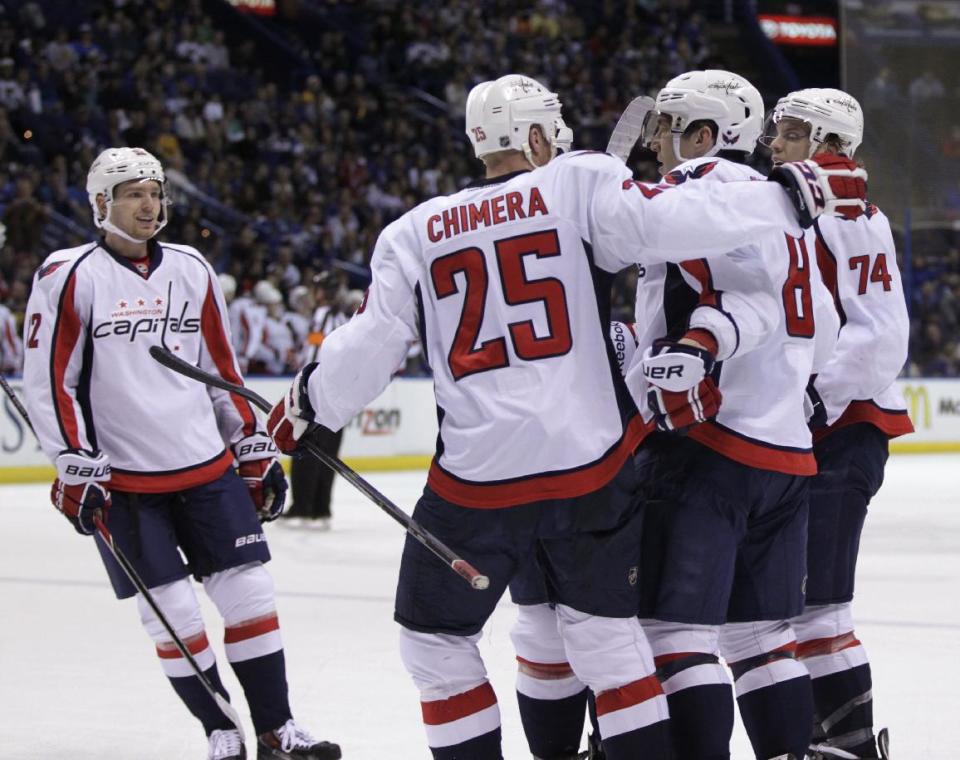 Washington Capitals' Alex Ovechkin (8) is congratulated by teammates Jason Chimera (25), John Carlson (74) and Mike Green (52) after he scored his 50th goal of the season, during the first period of an NHL hockey game against the St. Louis Blues, Tuesday, April 8, 2014 in St. Louis.(AP Photo/Tom Gannam)