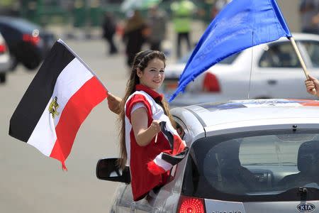 A girl carries a national flag while riding in a car as people gather in Tahrir square to celebrate an extension of the Suez Canal, in Cairo, Egypt, August 6, 2015. REUTERS/Mohamed Abd El Ghany