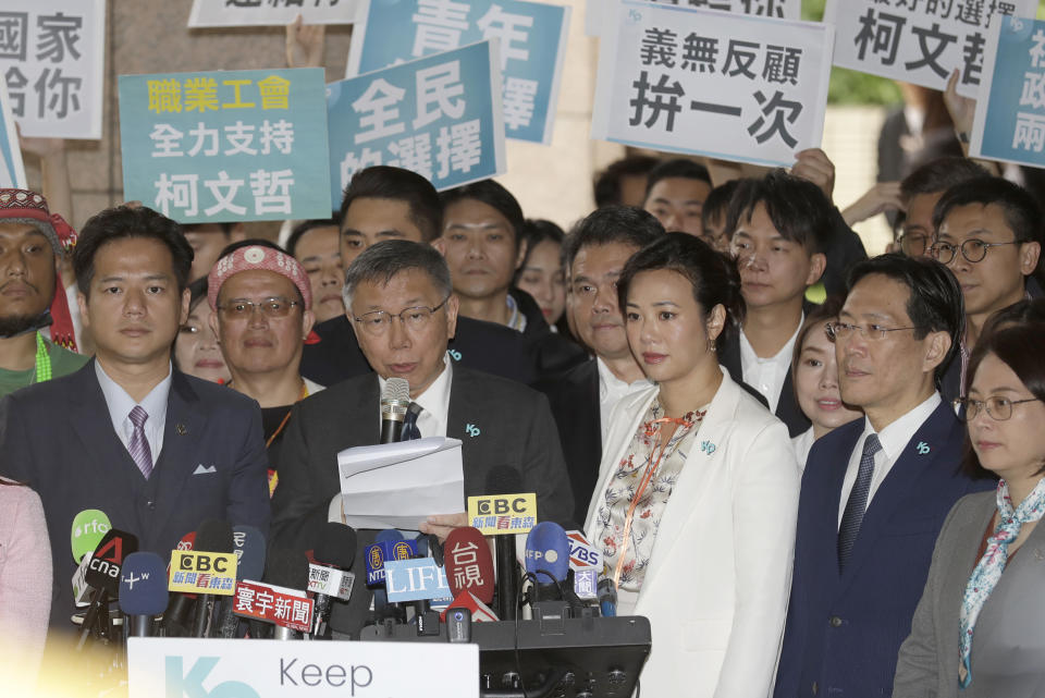 Taiwan's Taiwan People's Party (TPP) presidential candidate Ko Wen-je, center left, with his vice president candidate Cynthia Wu Hsin-ying, center right, answers to the media outside of Central Election Commission in Taipei, Taiwan, Friday, Nov. 24, 2023. (AP Photo/ Chiang Ying-ying)