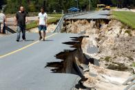 <p>Anwohner am Damm des Patricia Lake in Boiling Spring Lakes im US-amerikanischen Bundesstaat North Carolina gehen eine Straße entlang, die vom Hurrikan Florence zerstört wurde. (Bild: REUTERS/Jonathan Drake) </p>