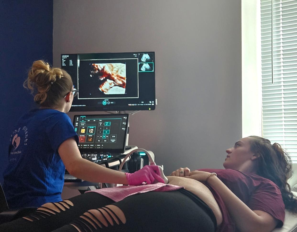 Timber Colcord performs an ultrasound on Gracie Oliver. The equipment allows mothers and families to see 4D images of the baby.