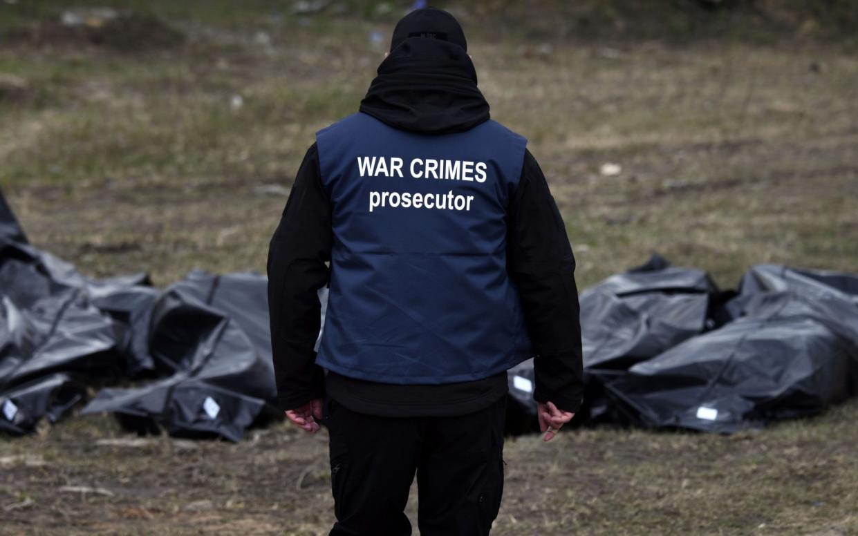 Investigators pull bodies from a mass grave while assessing evidence of war crimes in Bucha, Ukraine