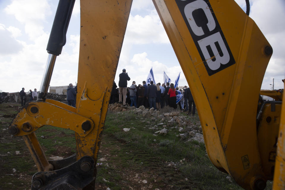 Protesters carrying Israeli flags heckle a news conference by European Union officials visiting the construction site for Givat Hamatos settlement in Jerusalem, Monday, Nov. 16, 2020. The Israel Land Authority announced on its website Sunday that it had opened up tenders for more than 1,200 new homes in the settlement of Givat Hamatos, according to the Israeli anti-settlement group Peace Now. (AP Photo/Maya Alleruzzo)