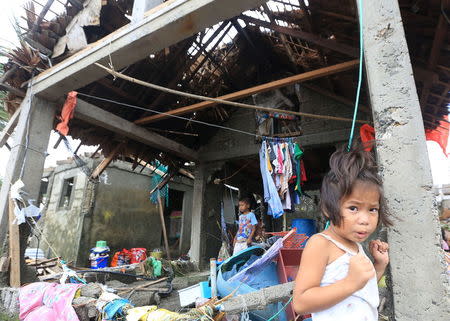 Residents are seen at their damaged houses after strong winds and heavy rains brought by typhoon Melor battered Barcelona town, Sorsogon province, central Philippines December 15, 2015. REUTERS/Eduardo Guinio