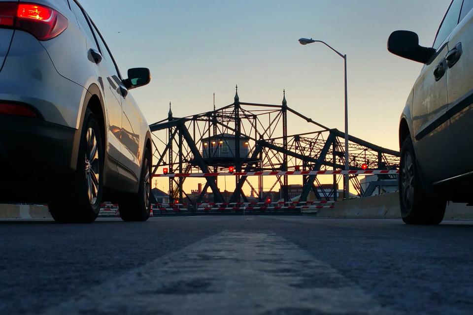 Cars wait for the New Bedford-Fairhaven Bridge to open as the sun sets.