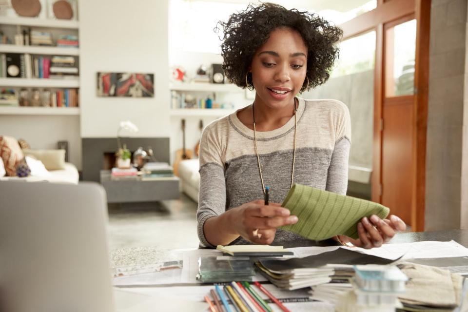 A woman considers fabric swatches in her living room