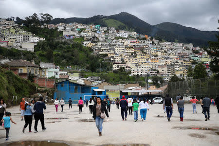 People walk outside a school used as a polling station during the presidential election, in Quito, Ecuador April 2, 2017. REUTERS/Mariana Bazo