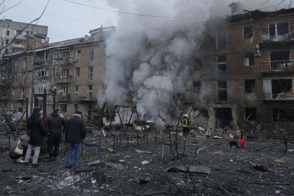 People check a damaged building as emergency personnel work at the scene of a Russian shelling in the town of Vyshgorod outside the capital Kyiv, Ukraine, Wednesday, Nov. 23, 2022. Authorities reported power outages in multiple cities of Ukraine, including parts of Kyiv, and in neighboring Moldova after renewed strikes Wednesday struck Ukrainian infrastructure facilities. Multiple regions reported attacks in quick succession, suggesting a barrage of strikes. In several regions, authorities reported strikes on critical infrastructure. (AP Photo/Efrem Lukatsky)