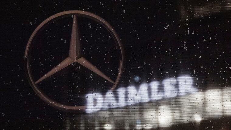 Das Logo der Daimler-AG ist an der Konzernzentrale zu sehen, im Vordergrund ist ein Mercedes-Stern auf einer Flagge abgebildet. Foto: dpa
