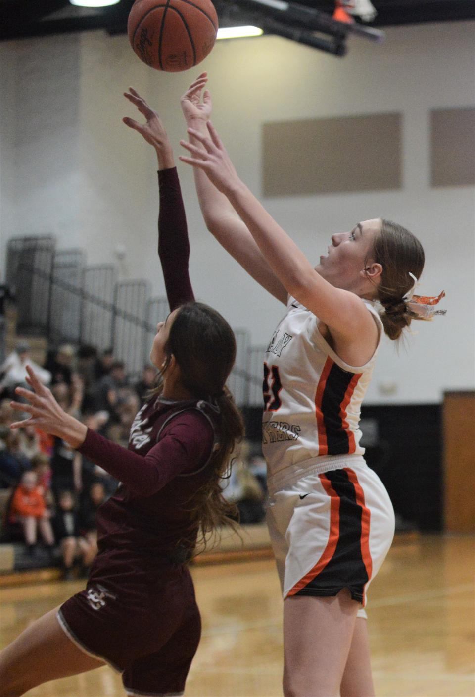 New Lexington's Abby Wilson (white) and John Glenn's Mckinzi Linscott (maroon) go up for a loose ball in Saturday's game. The Panthers won 61-25.